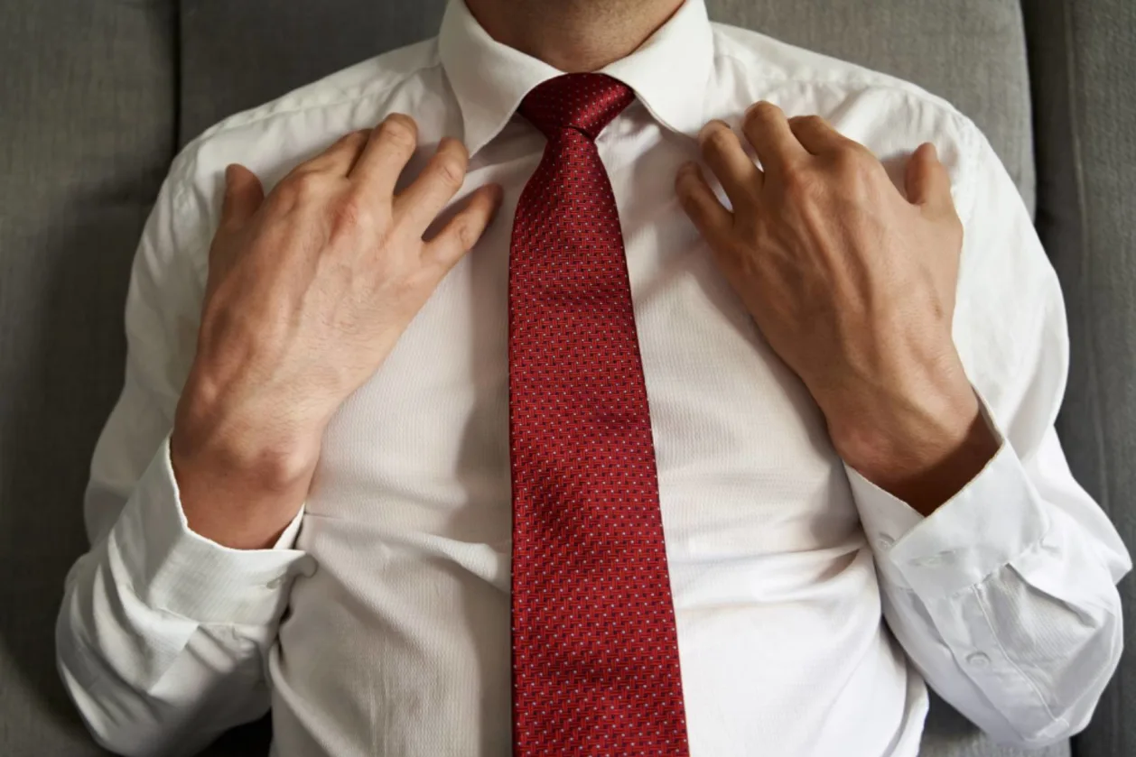 Businessman practicing EFT tapping therapy on collarbone